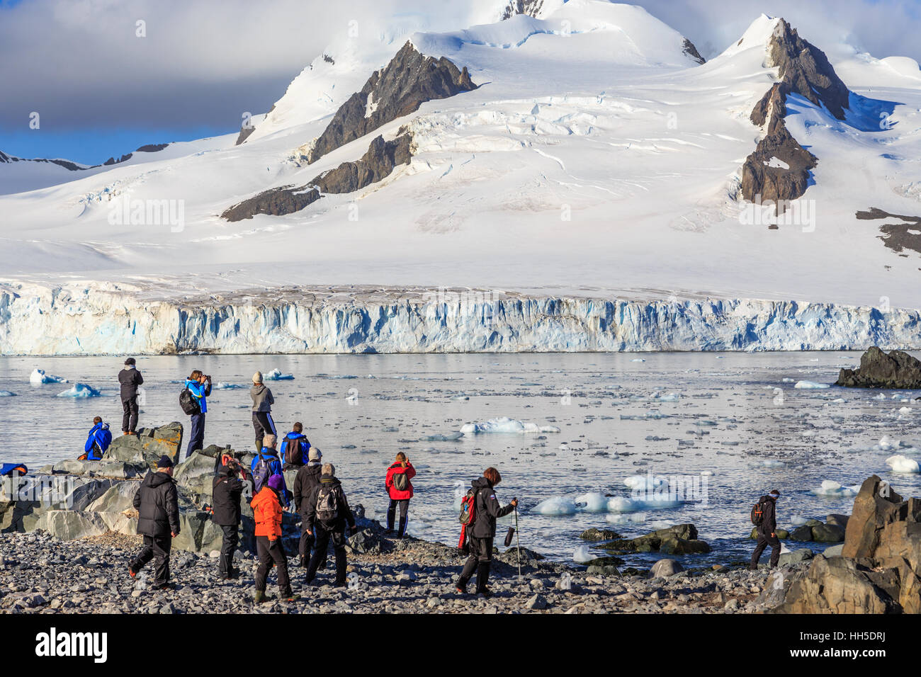 Gruppe von Touristen auf der Suche auf dem Gletscher auf der steinigen Küste von Half Moon Island, Antarktis Stockfoto