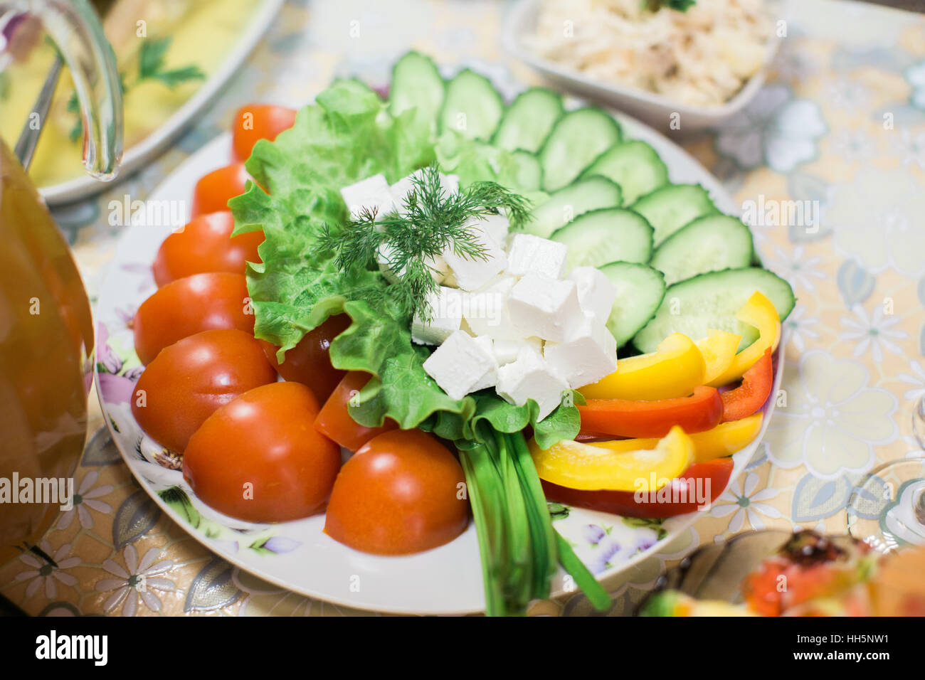 Tomate, Gurke, weißer Käse mit Salat auf Teller. Gemüse auf Teller. Stockfoto