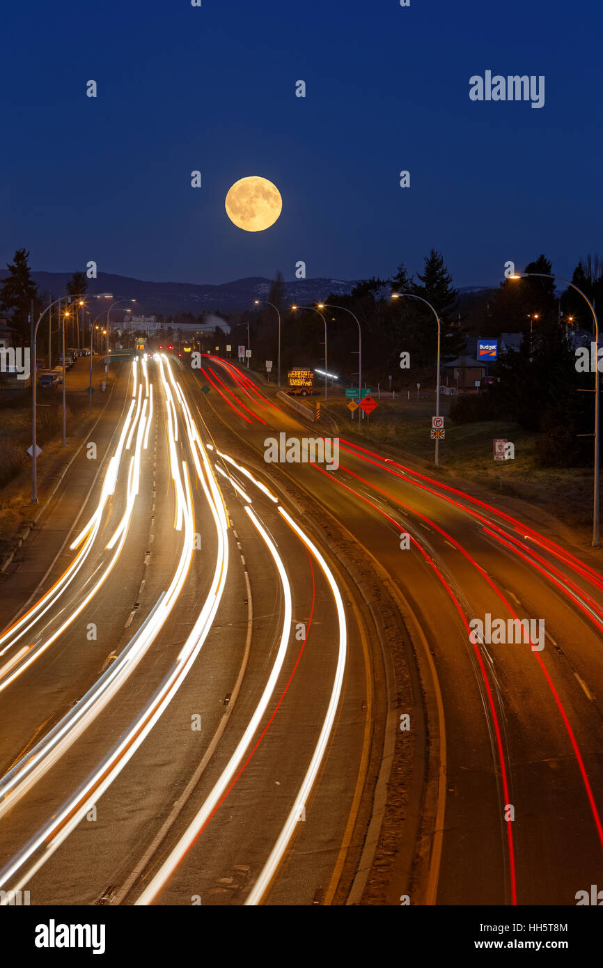 Vollmond-Einstellung über Verkehr am Transcanada Highway in Victoria-Victoria, British Columbia, Kanada. Stockfoto
