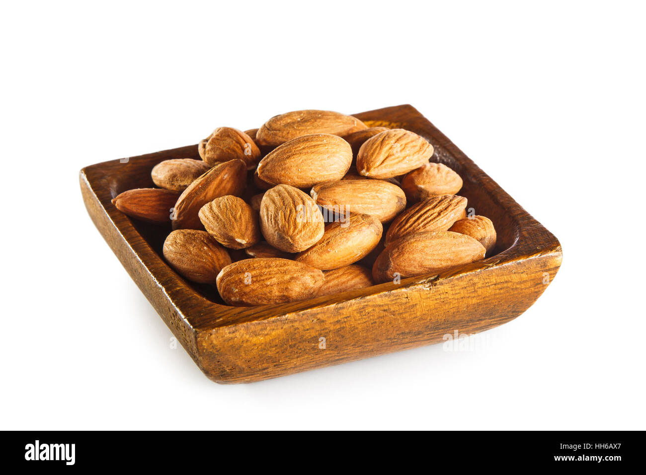 Mandeln in Holzschale isoliert auf weißem Hintergrund Stockfoto
