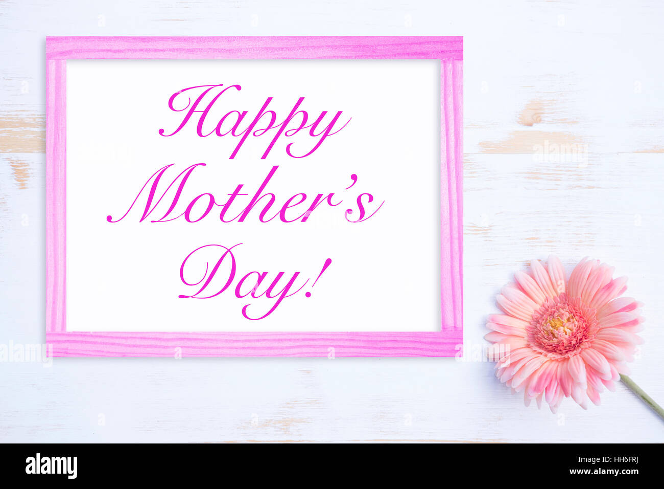 rosa Blume auf weißer Holztisch mit Rahmen und Worte alles Gute zum Muttertag Stockfoto
