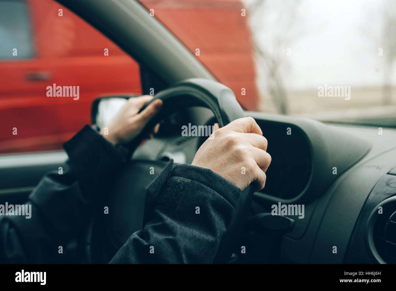 Weibliche Hände am Lenkrad, Frau Autofahren auf kalten Winternachmittag Stockfoto