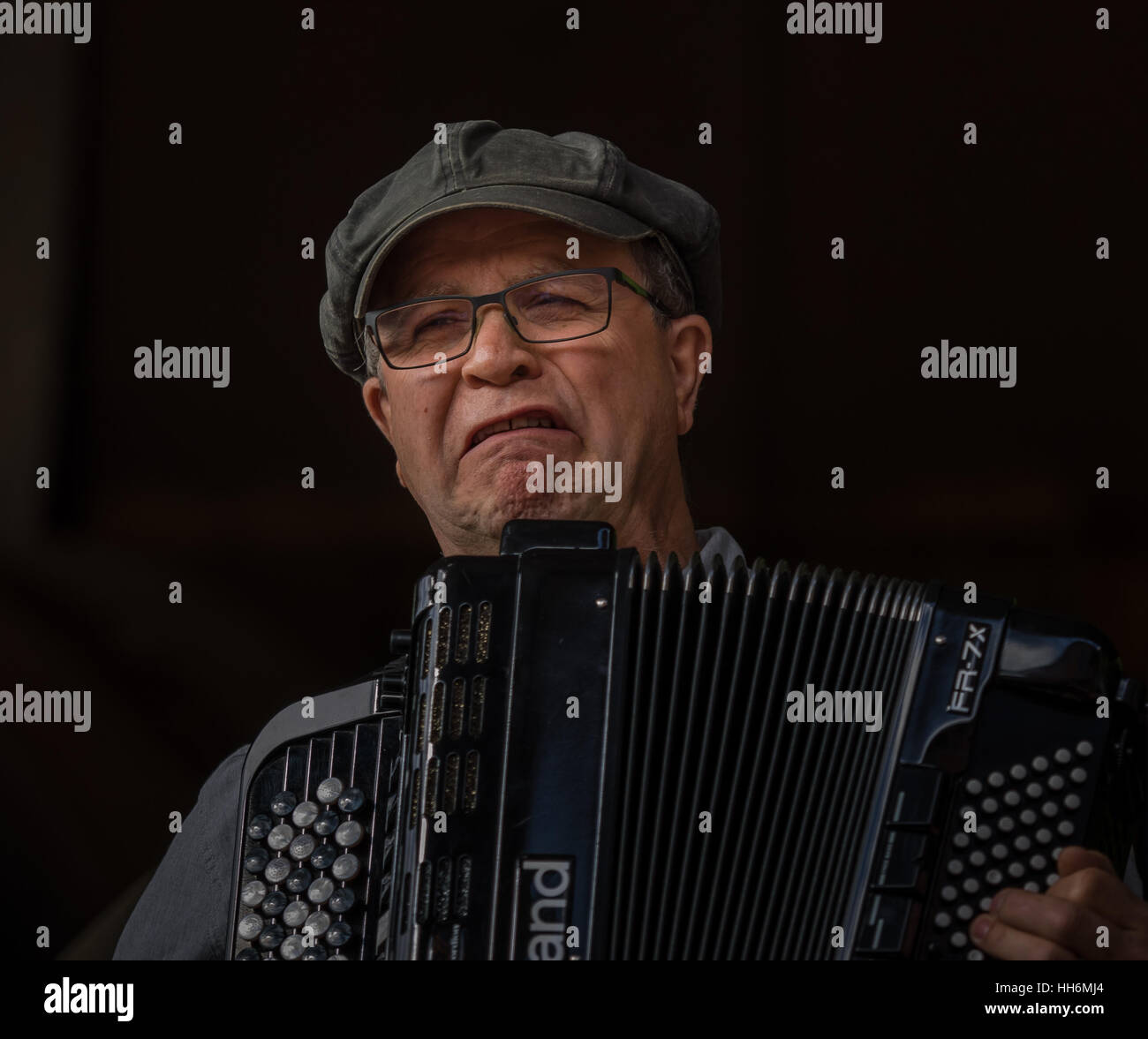 Ehrliches Porträt der männlichen Musiker einen Hut tragen, spielen ein Akkordeon und Suchen sehr traurig Stockfoto