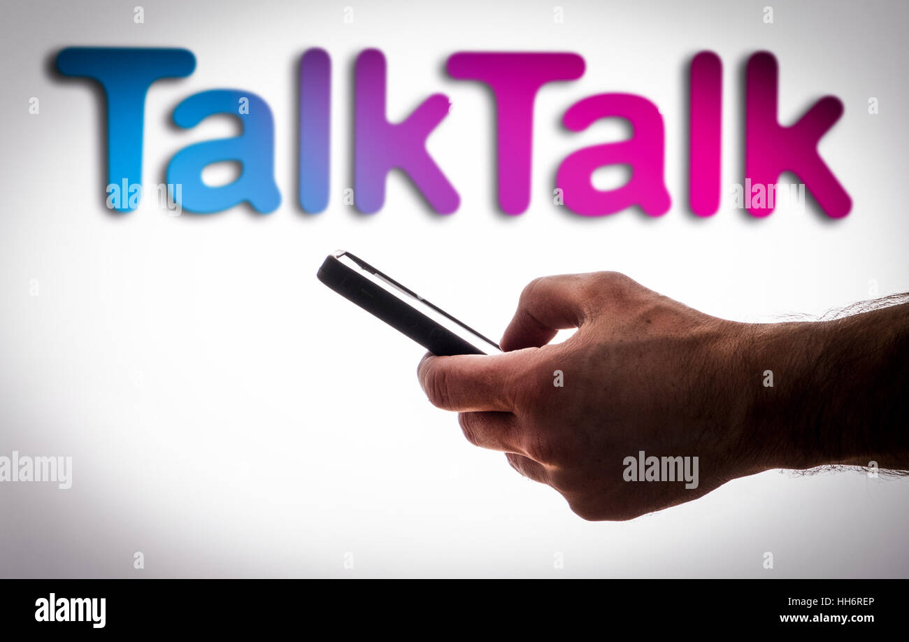 Ein Mann mit einem Mobiltelefon vor ein TalkTalk-logo Stockfoto
