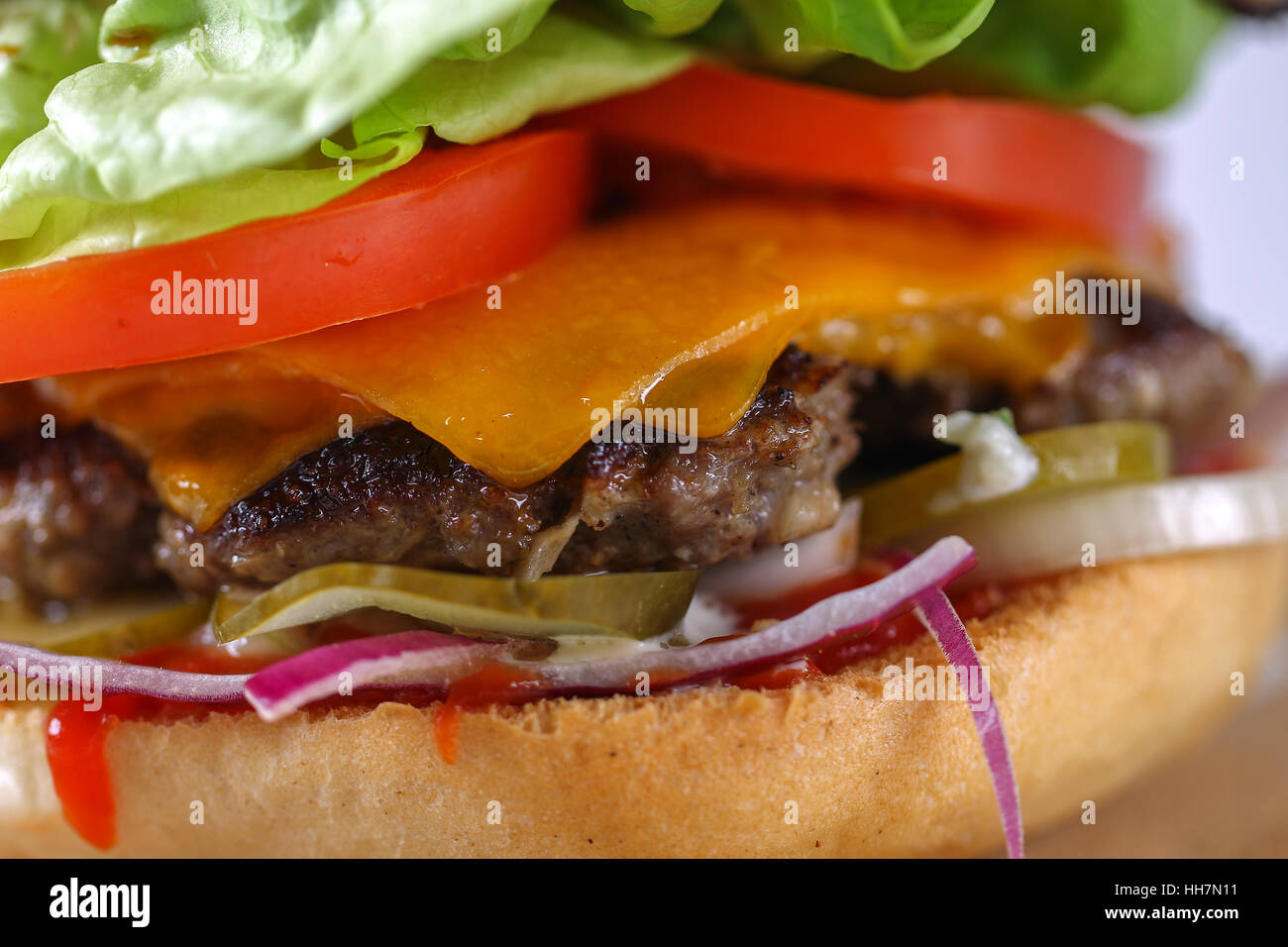 Leckere Käse-Beef-Burger mit Cheddar, Barbecue-Sauce, Tomaten, Gurken ...