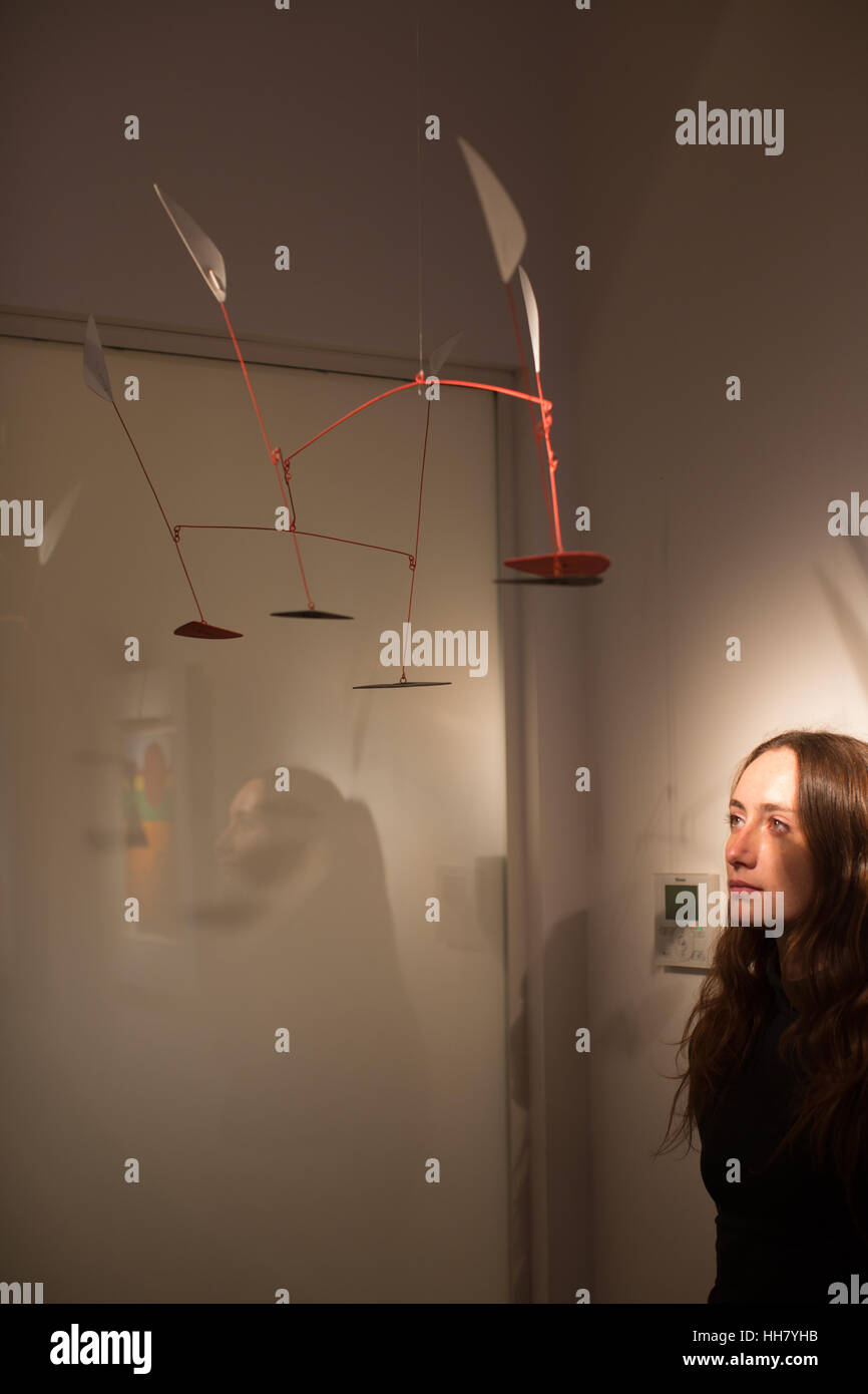 London, UK. 17. Januar 2017. 3 Feuilles Noirs, 5 blanches, 2 Rouges (1960) von Alexander Calder, mit Galerie-Assistent, Carlota Dennis-Lovaglio auf einer Presse-Ansicht vor der Eröffnung der Ausstellung Kunst revolutionäre (eine Sammlung von Stücken inspiriert von den spanischen Pavillon auf der 1937 Paris Ausstellung, darunter Werke von Picasso und Miro) in der Bürgermeisterwahl Gallery in 6 Duke St, London, 18. Januar 10 Februar 2017 Credit : Live-News Roger Garfield/Alamy Stockfoto