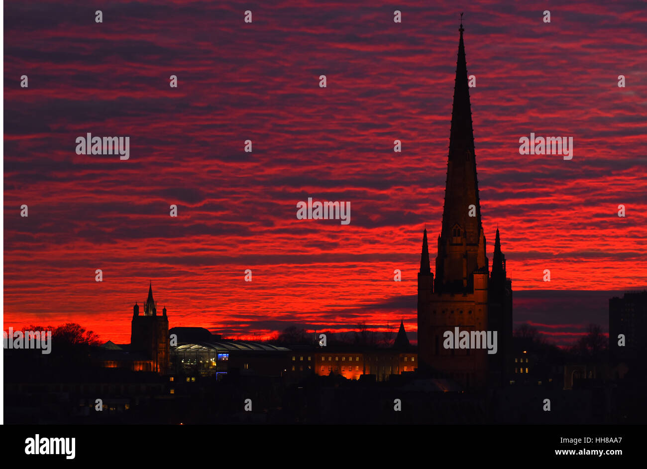 Die Sonne geht über der Norfolk Stadt Norwich erstellen Silhouetten von St Peter Mancroft-church(left), die Stadt Hall(center) und Norwich Cathedral(right). Bildnachweis: Simon Finlay Stockfoto