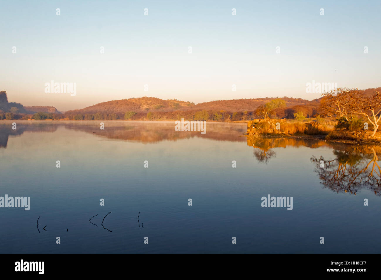 Die Sonne geht über einen See, Padam Talab Gießen eine Reflexion in der Oberfläche des Wassers. Stockfoto