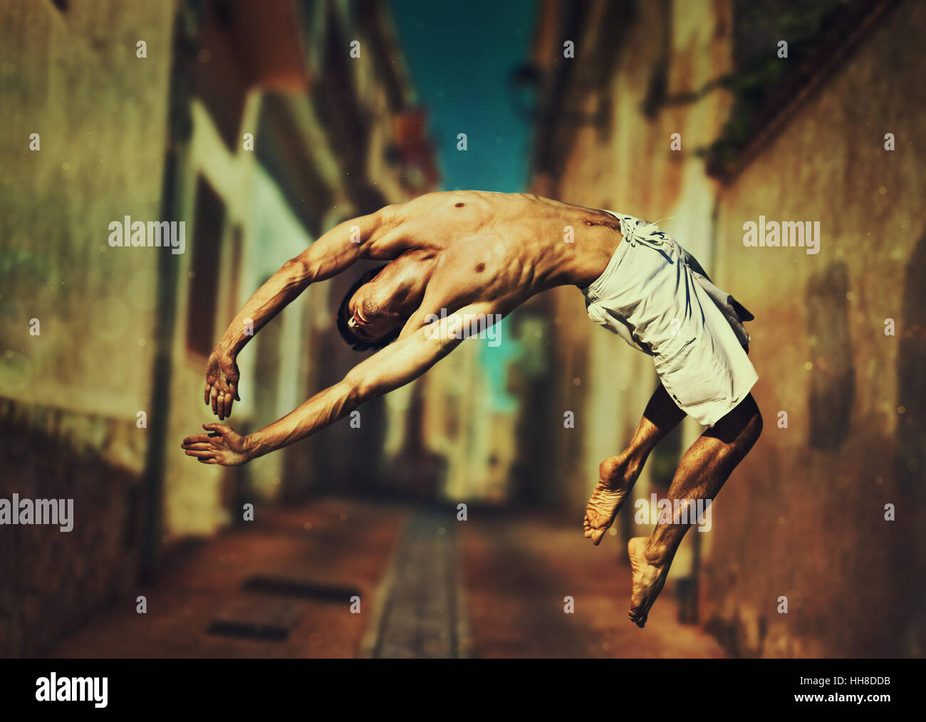 Junger Mann Tänzer springen auf alte Stadt Straße Hintergrund Stockfoto
