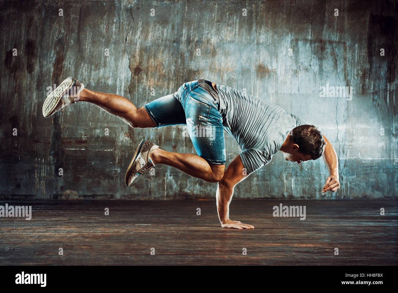 Starker junger Mann Breakdance auf alten Mauer Hintergrund Stockfoto