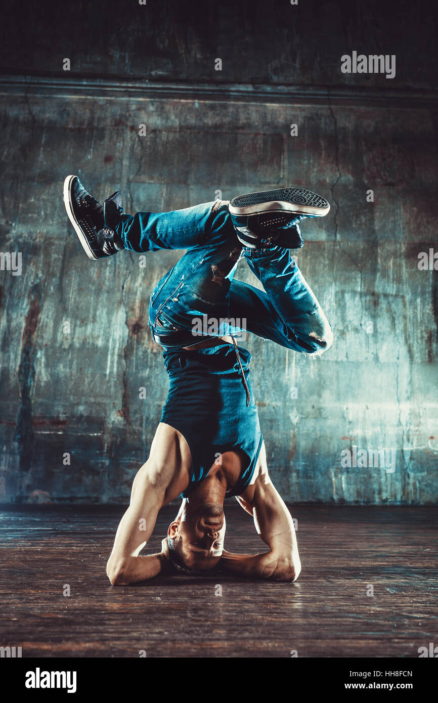 Junger Mann Breakdance auf alten Mauer Hintergrund. Vintage Film-Stil-Farben. Stockfoto