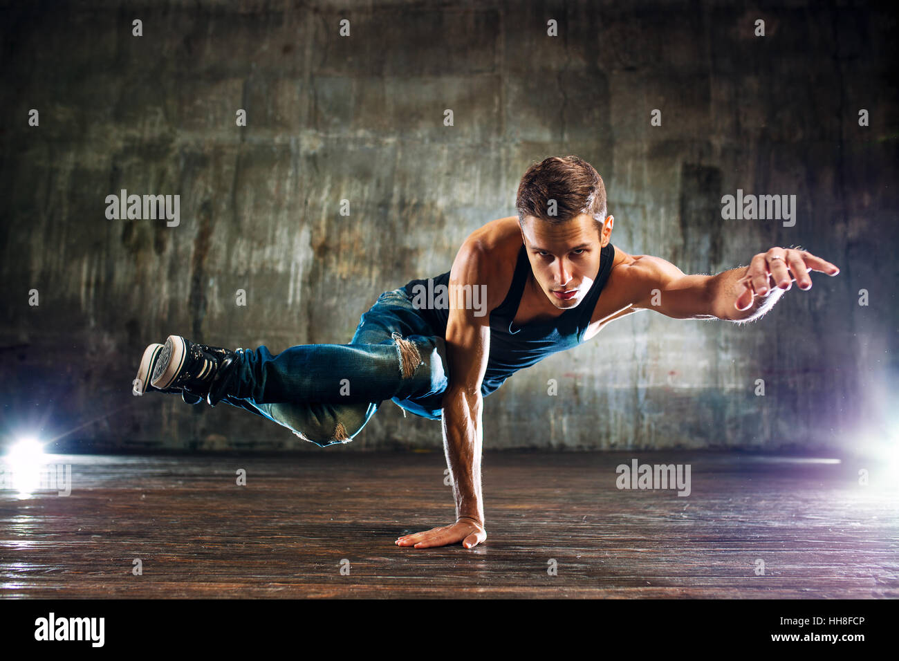 Junger Mann, Breakdance und stehen auf der einen Seite auf alten Mauer Hintergrund Stockfoto