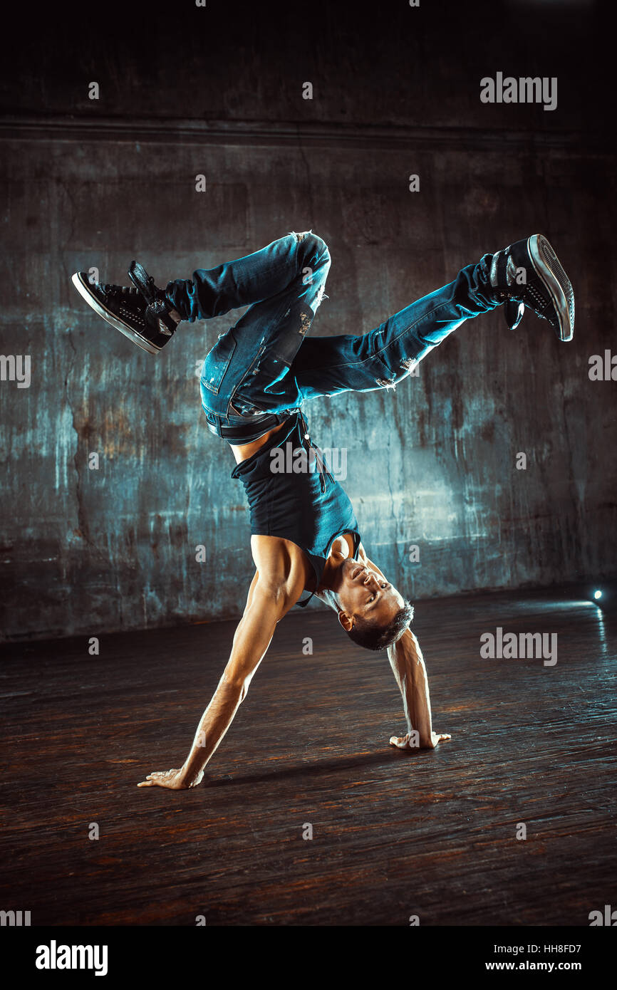 Junger Mann Breakdance auf alten Mauer Hintergrund. Vintage Film-Stil-Farben. Stockfoto