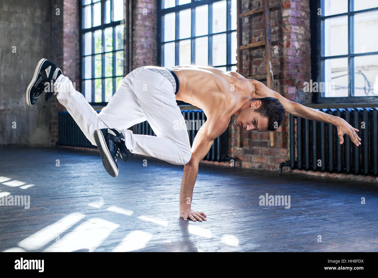 Junger Mann Breakdance in alten sonnigen städtische Interieur Stockfoto