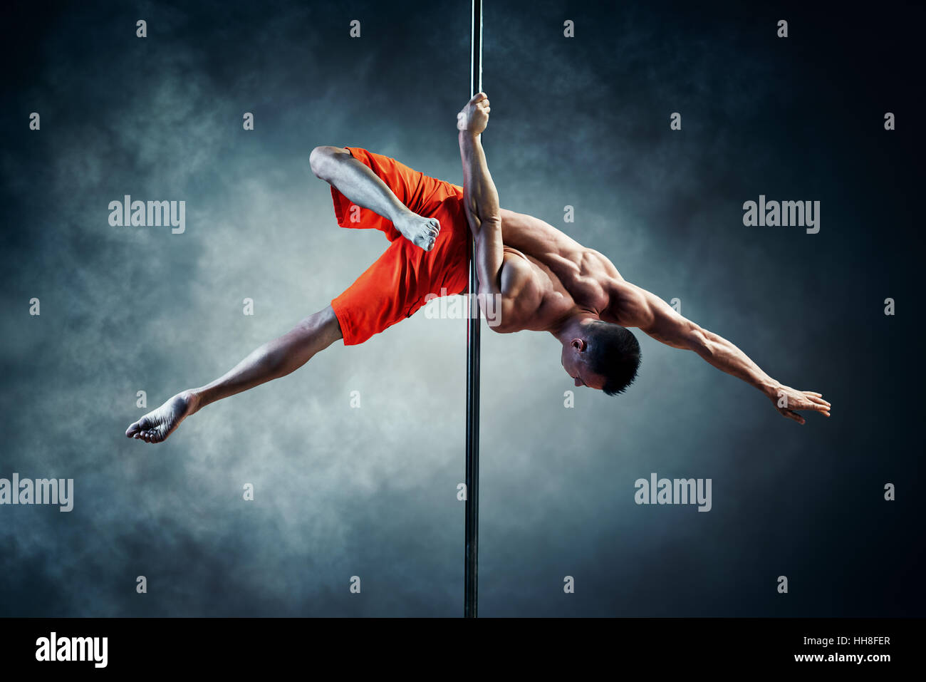 Junge starke Pole dance Mann mit Rauch-Effekt Stockfoto