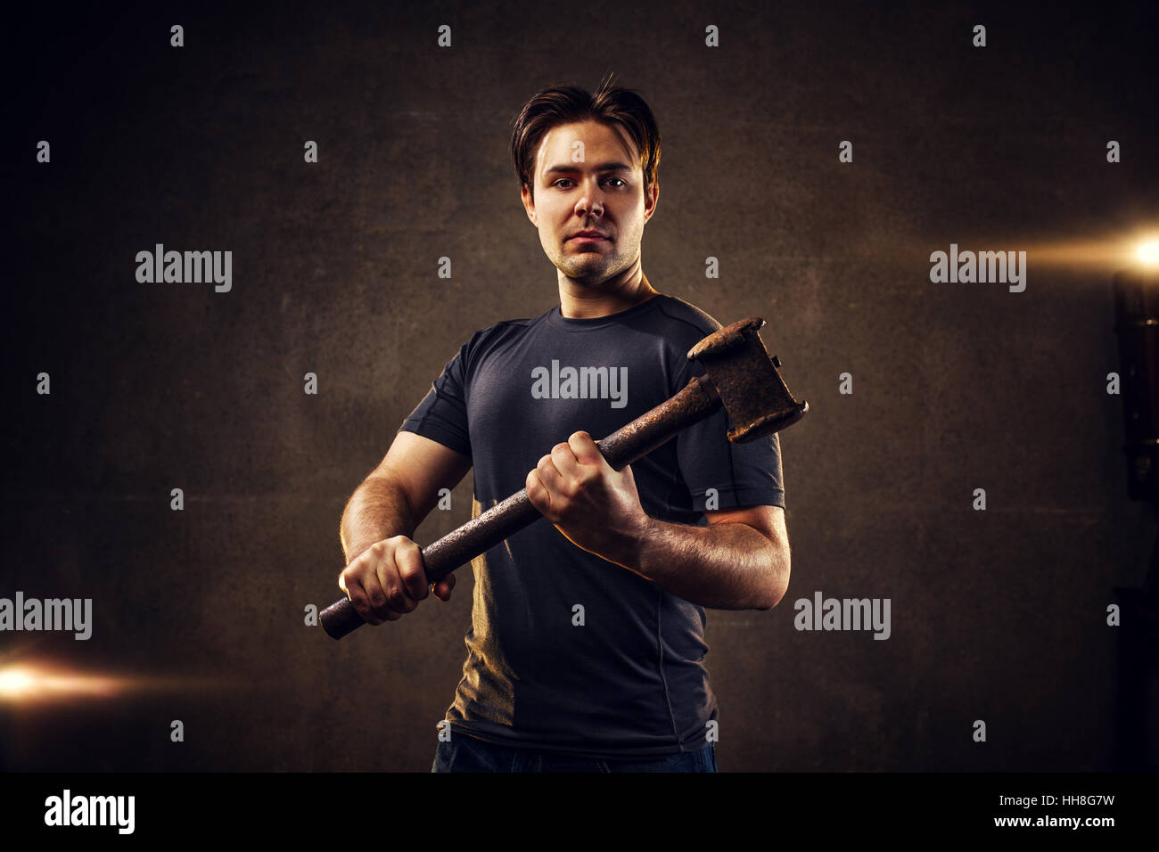 Starken Jüngling mit Hammer auf Wand Hintergrund Stockfoto