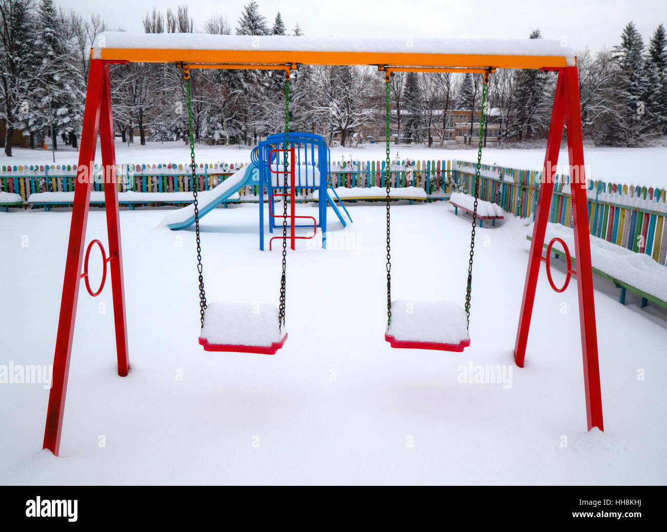 Kinderspielplatz im Winter mit Schnee bedeckt. Stockfoto