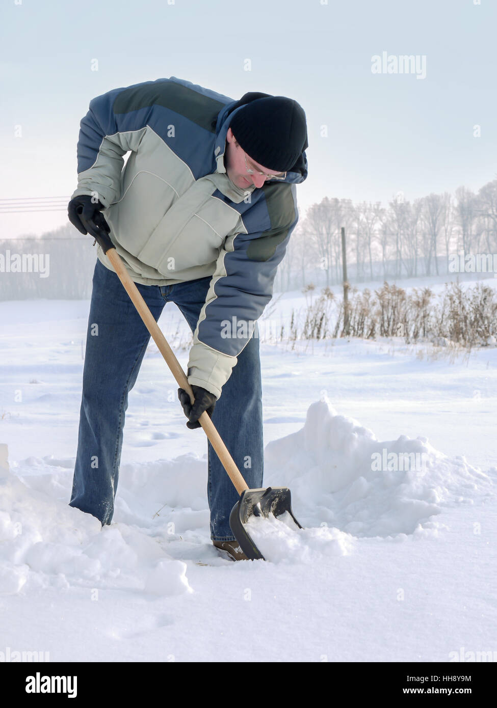 Mann seinem Hinterhof mit Schaufel nach schweren Schnee Pflügen Stockfoto