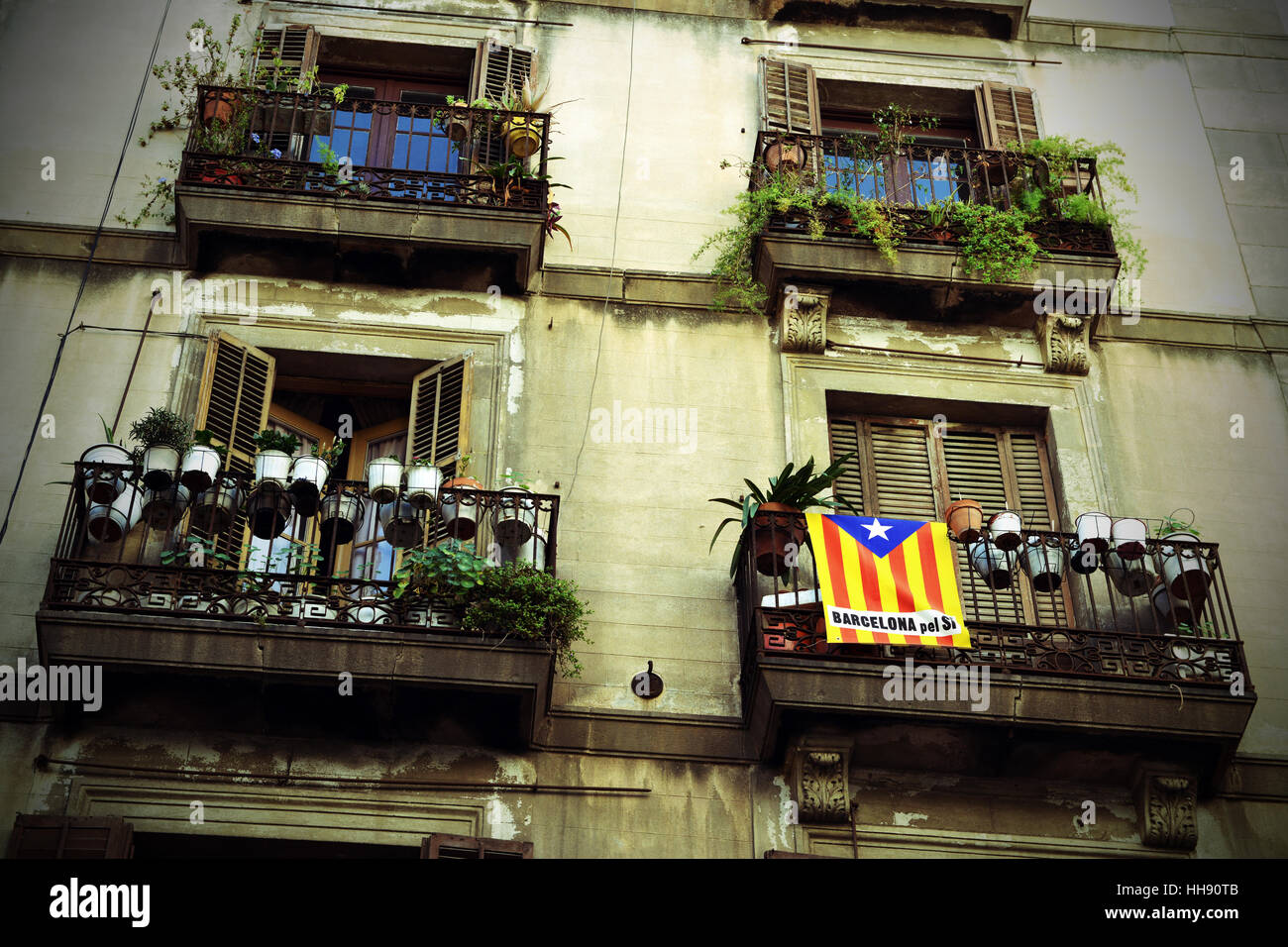 Eine katalanische Fahne drapiert über einen Balkon in einer Seitenstraße in Barcelona, Spanien Stockfoto