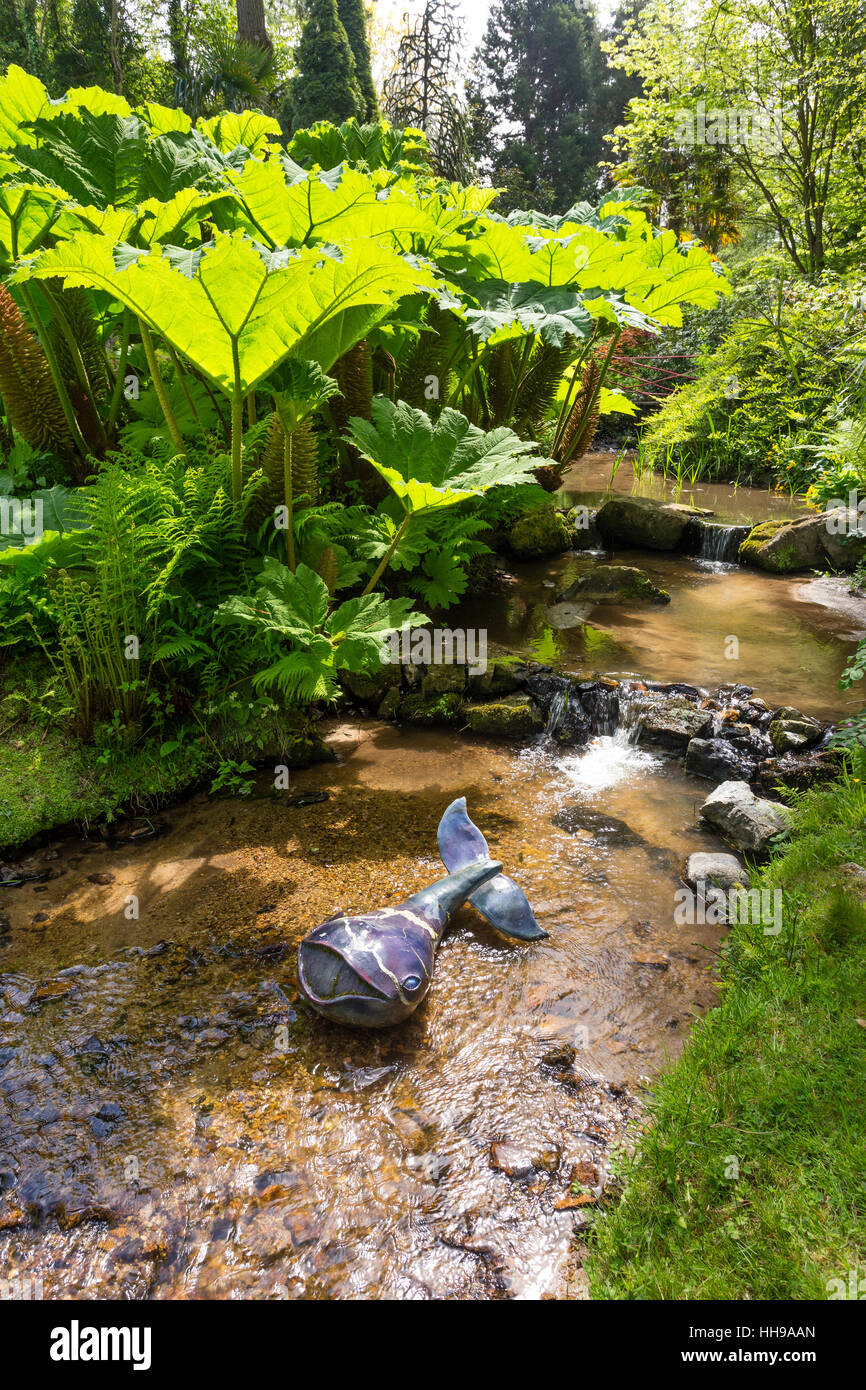 Wal (Keramik von Scelles & Giot) in einem Fluss mit Gunnera im Garten eine Hommage an Jacques Prévert. Frankreich, Manche, Saint-Germain-des-Vaux Stockfoto