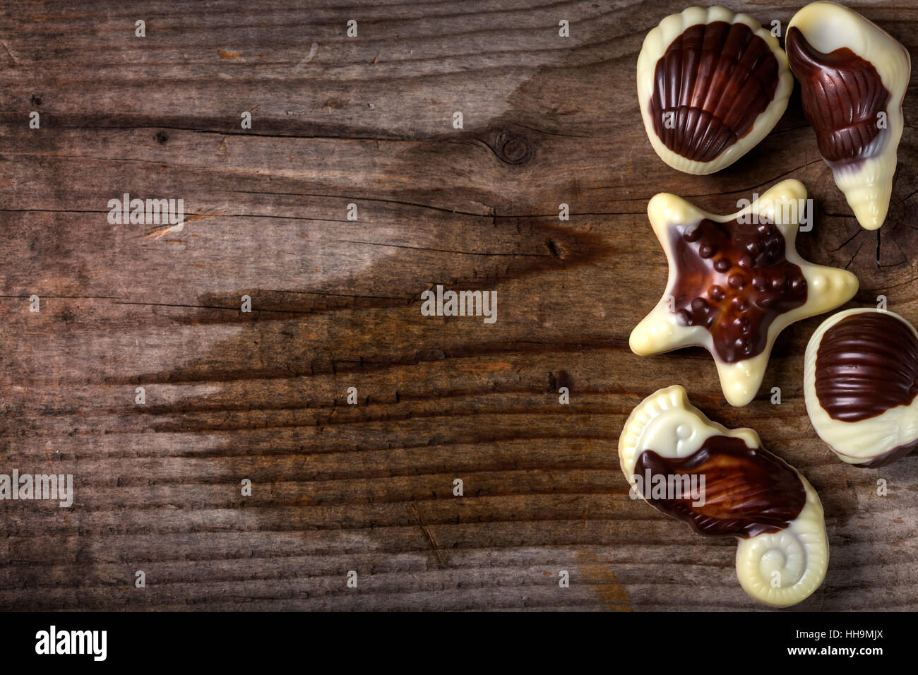 Muscheln-Süßigkeiten über rustikalen hölzernen Hintergrund mit Textfreiraum Stockfoto