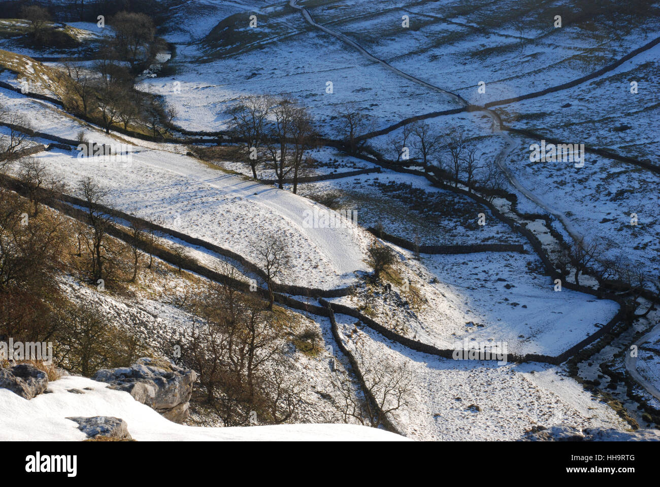 Die schneebedeckte Szene, die im Winter von der Sonne der niedrigen Winter über den Yorkshire Dales angestrahlt wird, zeigt trockene Steinmauern, die über die Dale schnappt Stockfoto
