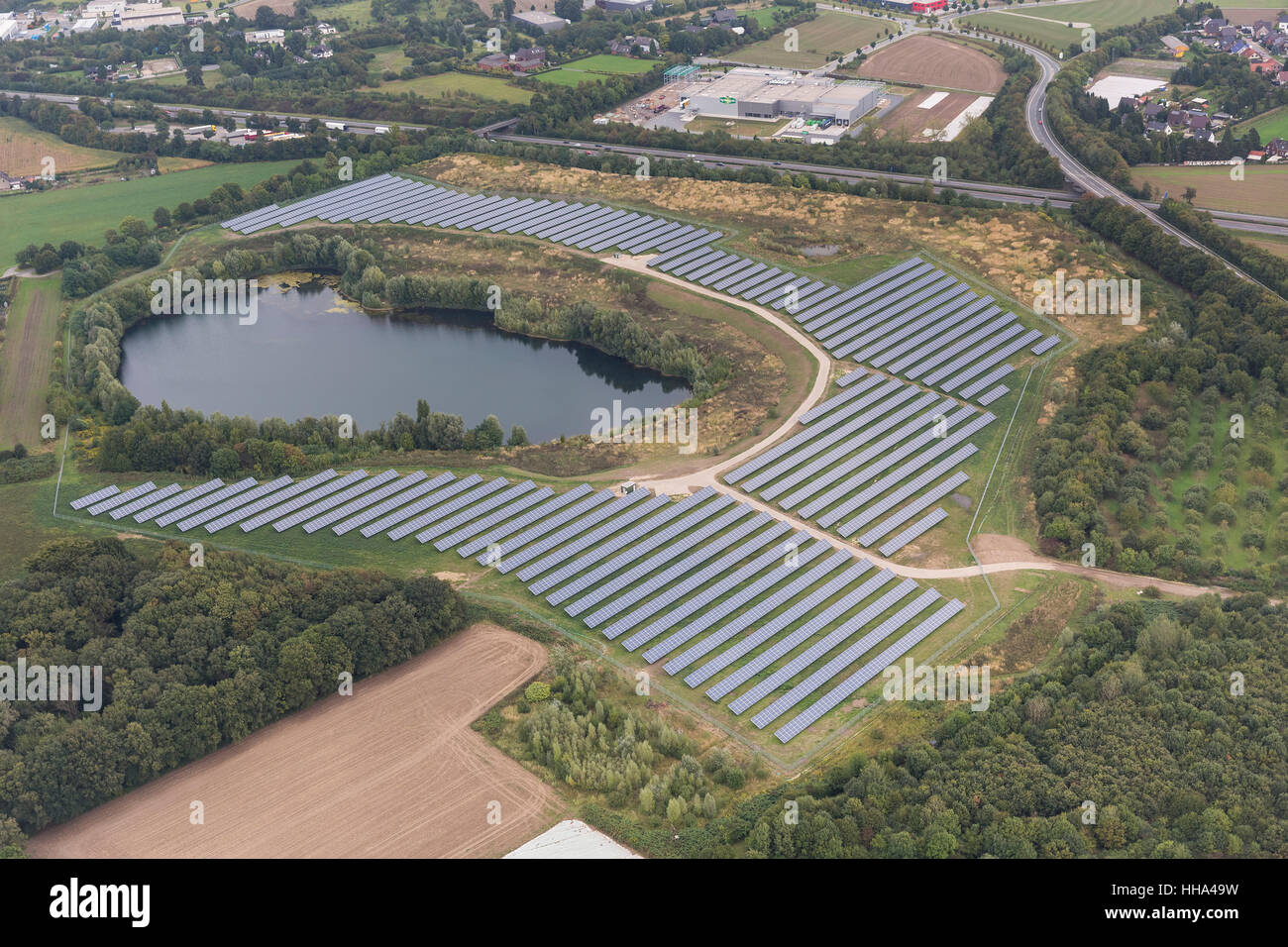 Mühlenfeld mit Sonnenkollektoren, kleiner See mit Photovoltaik-Anlage, Grafschafter Straße A57, Neukirchen, Niederrhein, Stockfoto