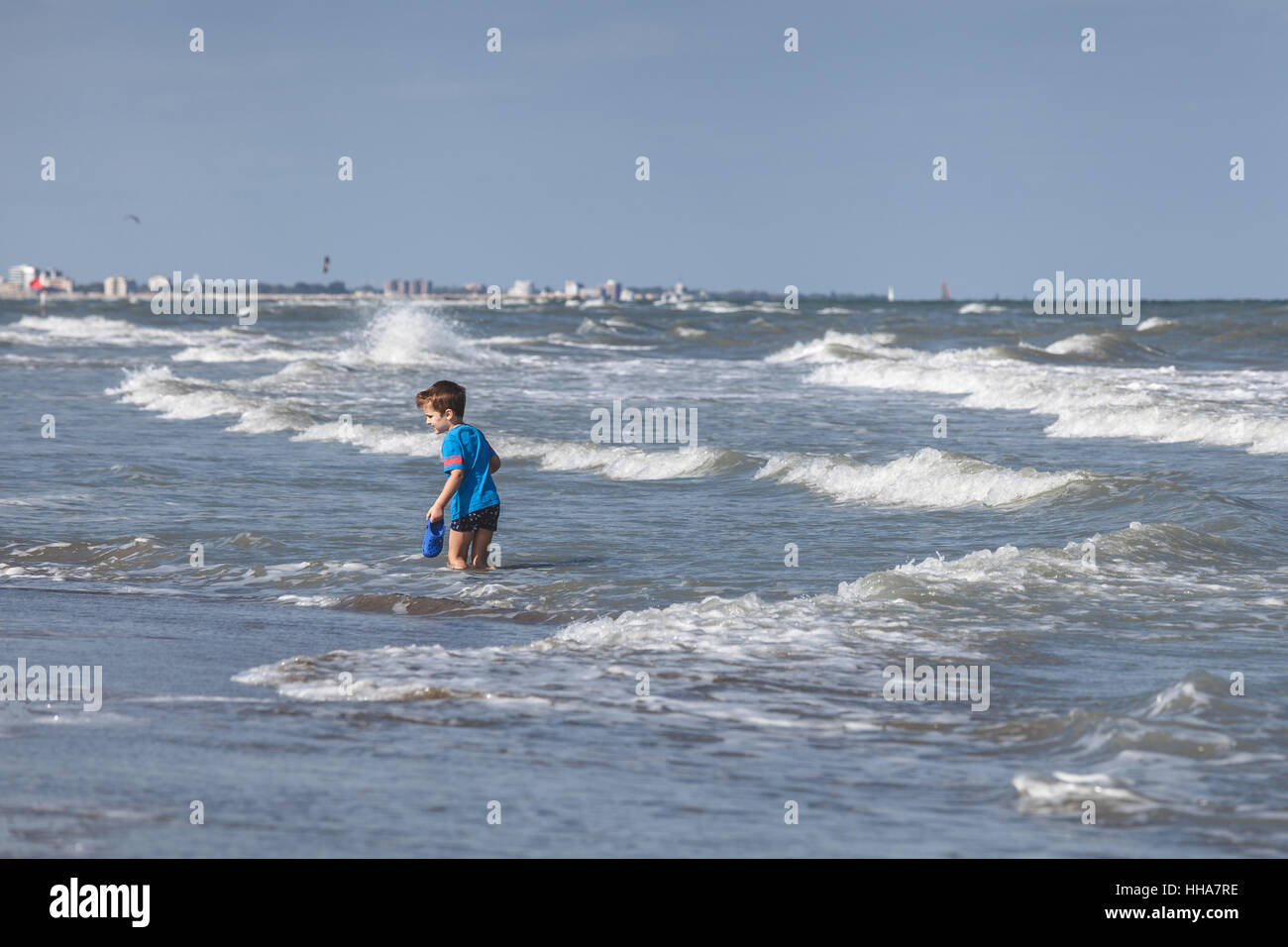 Kleiner Junge spielt im Wasser Meer mit Strand Hausschuhe in Adria Stockfoto