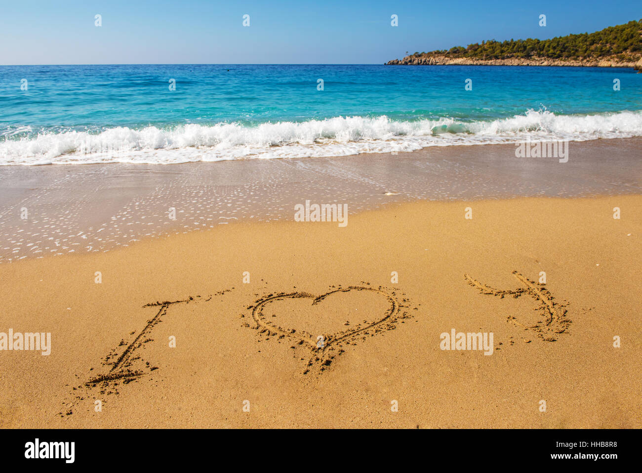 Nachricht Ich liebe Dich auf dem Sand mit Frau hand Zeichnung am Strand Stockfoto