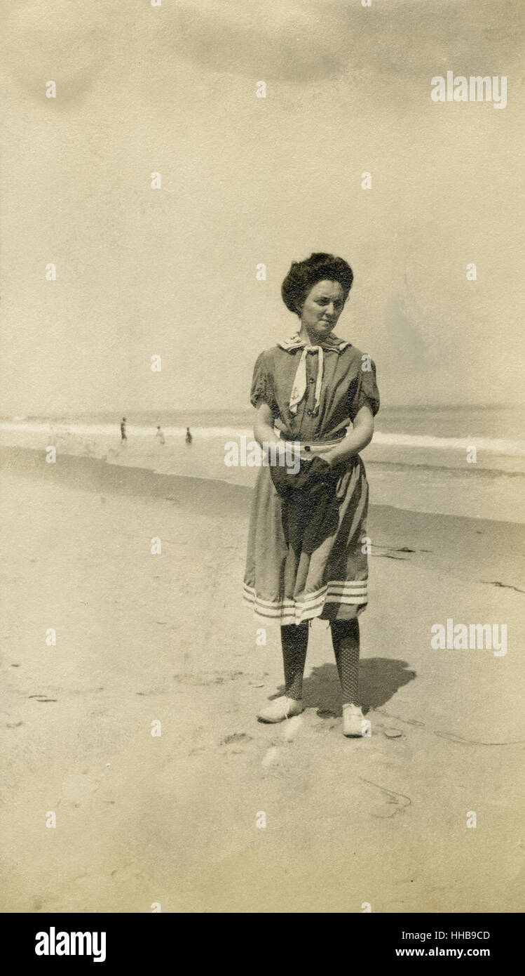 Antik 1908 Foto, Frau am Strand im viktorianischen Stil Badeanzug. Ort: New England, USA. QUELLE: ORIGINAL FOTOABZUG. Stockfoto