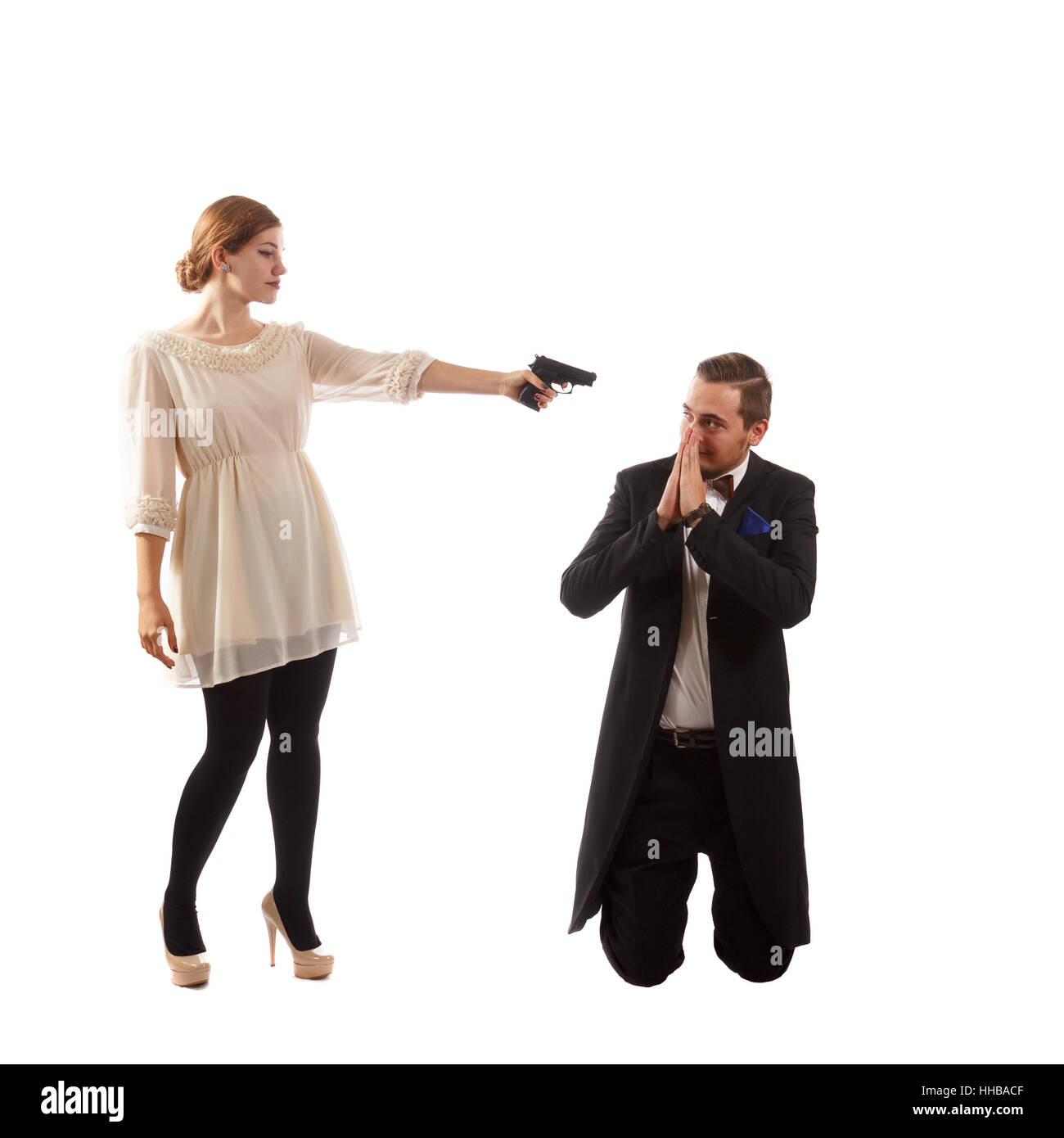 Eine Dame mit einer Pistole auf einen Mann in einem Anzug Stockfoto