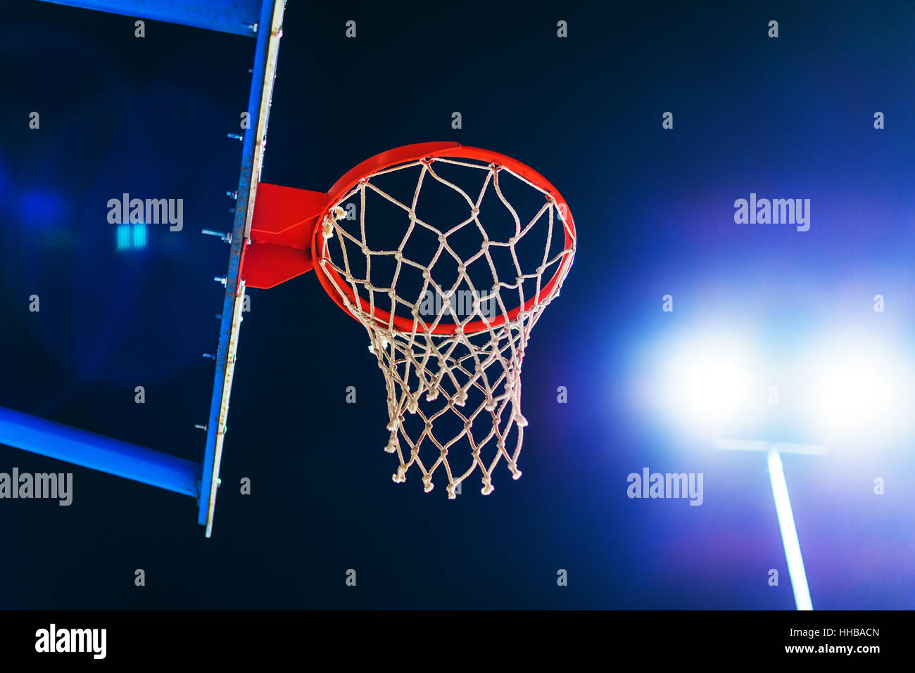 Flare-Basketballkorb auf Outdoor-Sportplatz in der Nacht mit Objektiv Stockfoto
