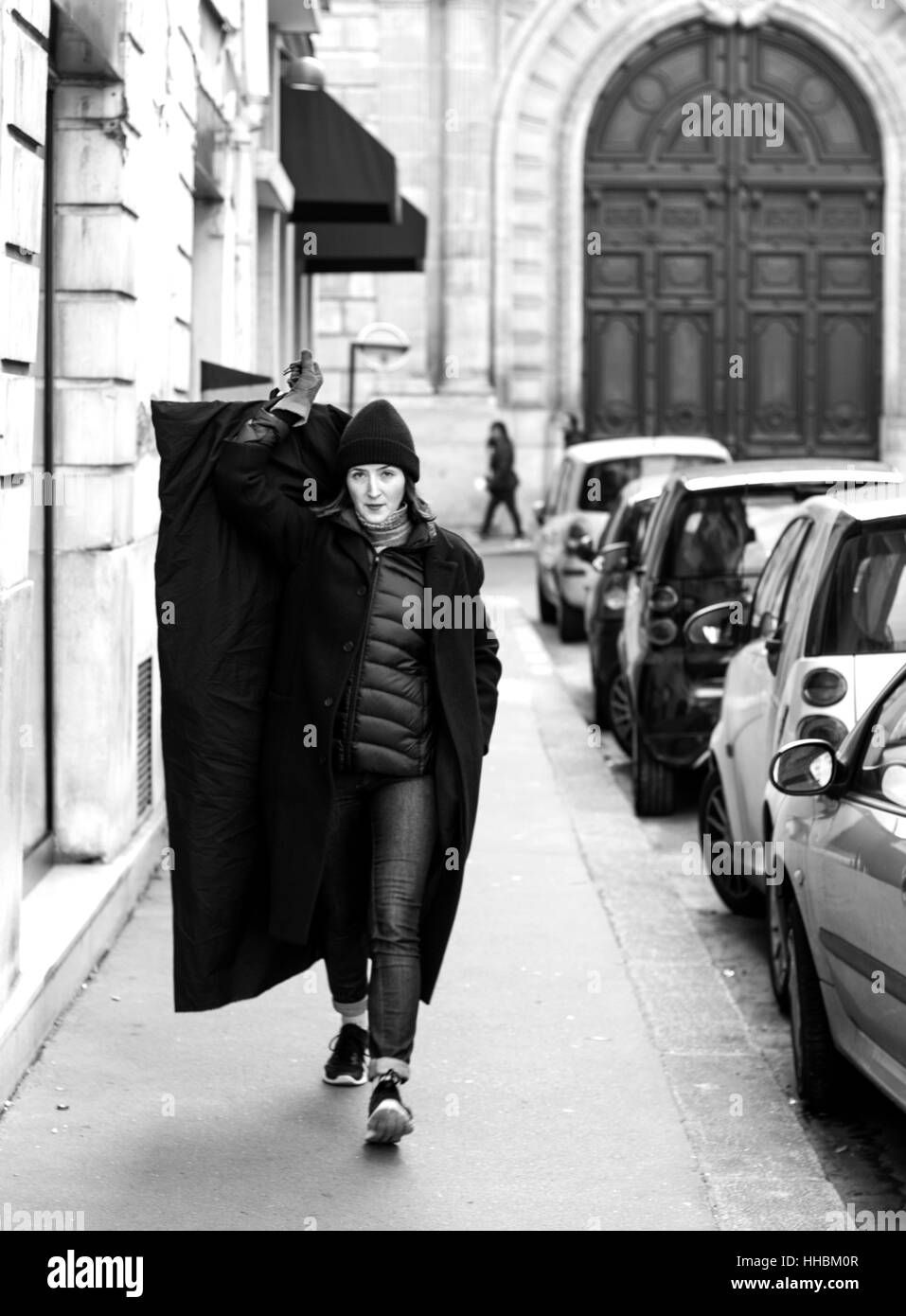 Frau tragen Kleidung mit erhobener Hand zu Fuß auf den Straßen von Paris. Stockfoto