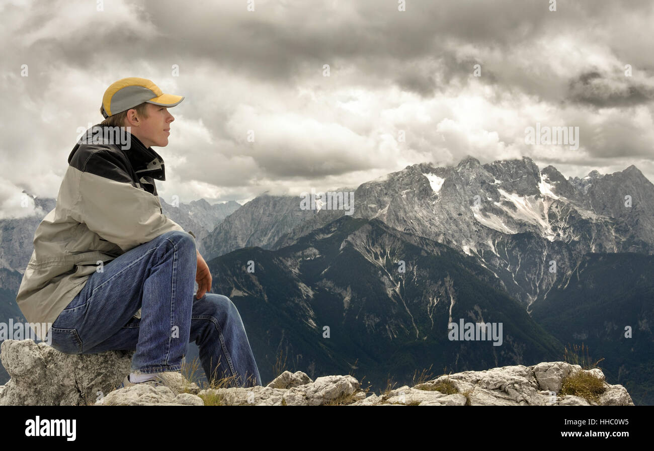 Junger Mann Sitzt bin erkundet Und Genießt Die Aussicht Auf Die Berglandschaft Stockfoto