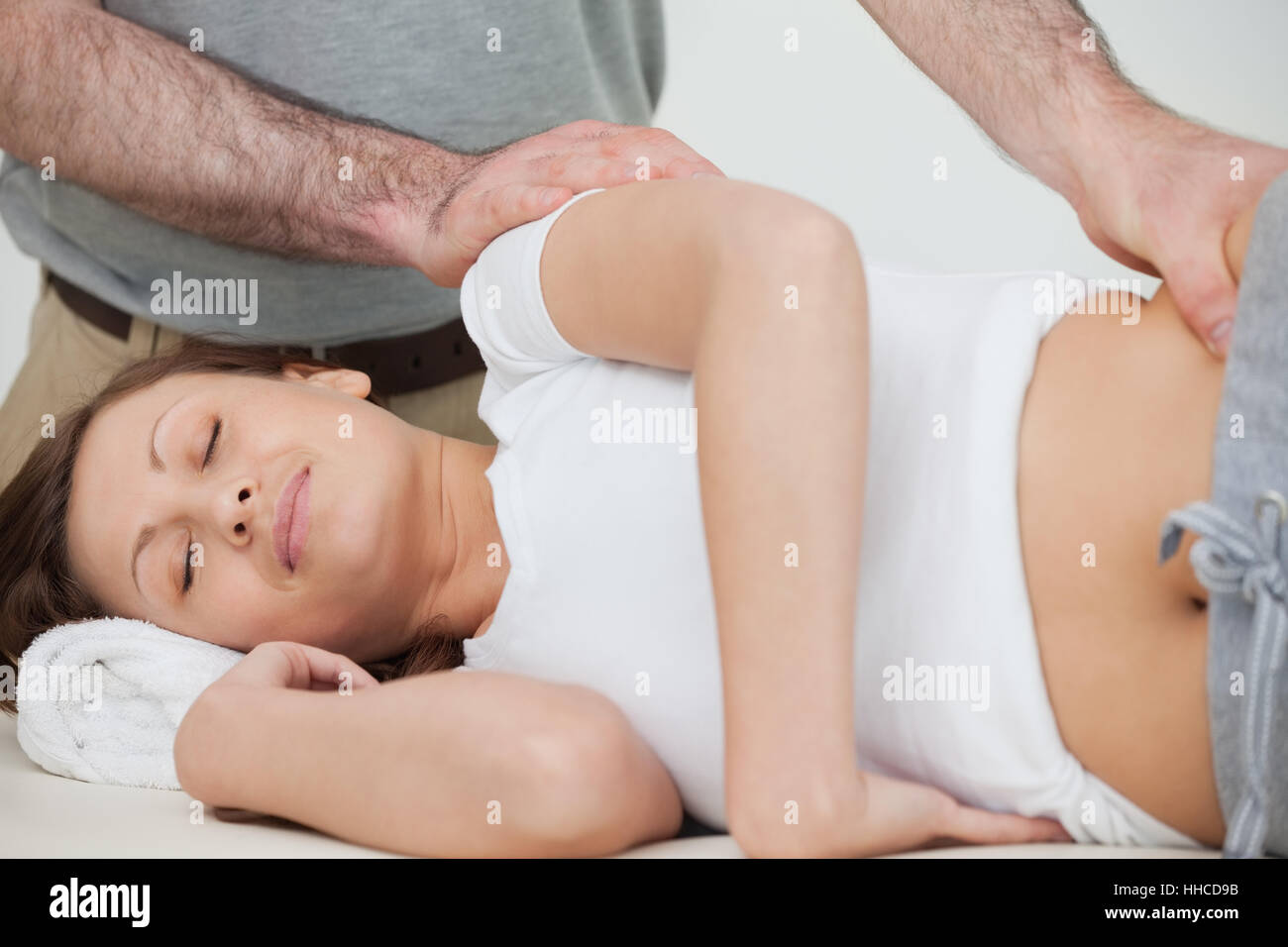 Brünette Frau von ihr Osteopath in einem Raum massiert Stockfoto