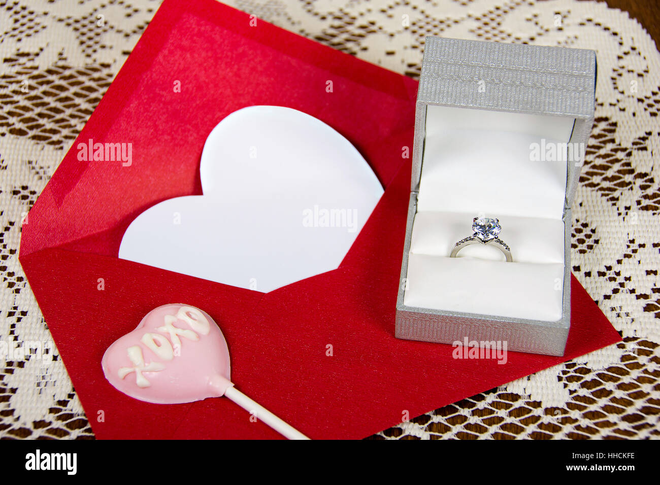 Diamantring in satin Box mit rosa Valentine Herzen Sauger auf rotes Kuvert Stockfoto