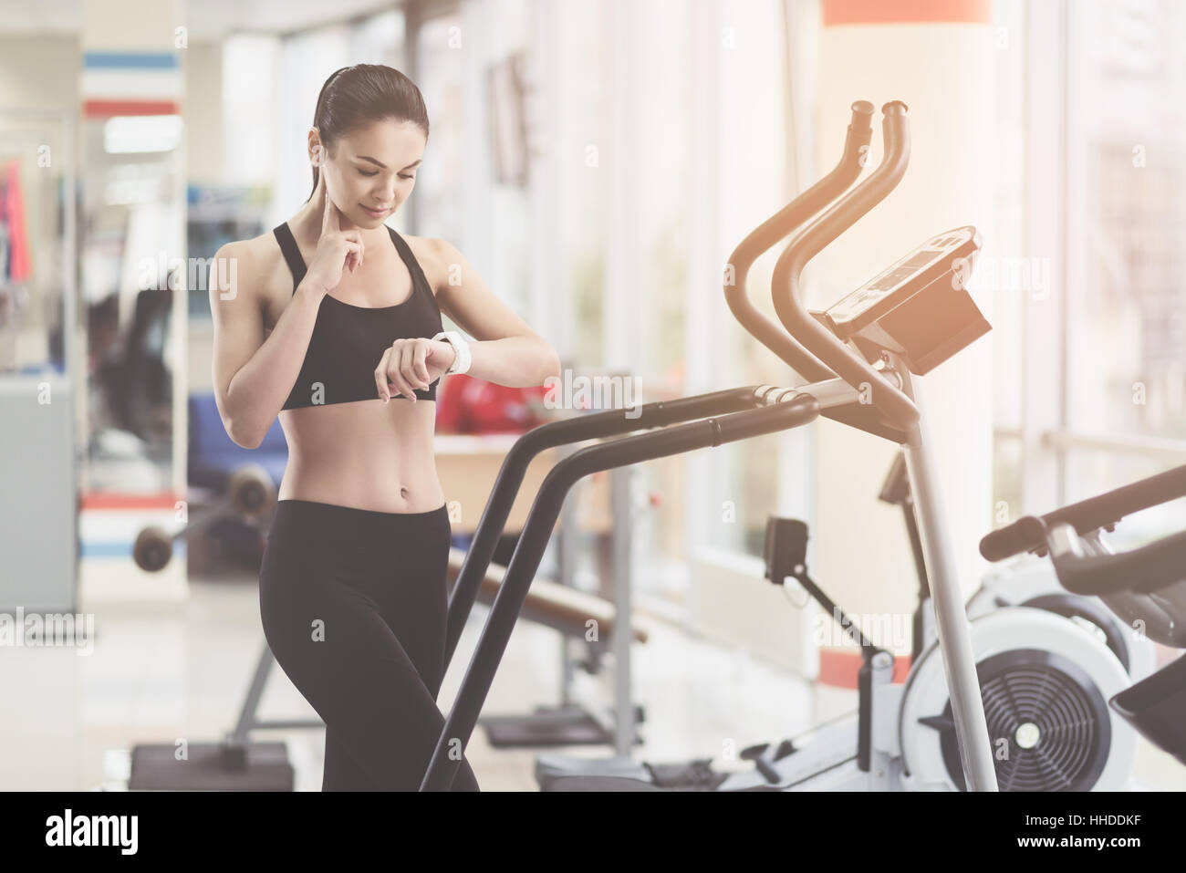 Schlanke Frau messen ihren Puls in einem Fitnessstudio Stockfoto