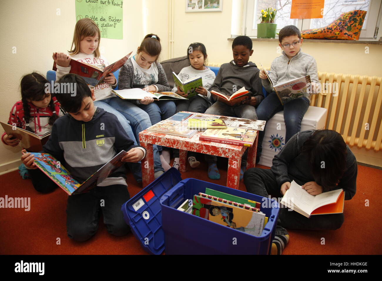 Schülerinnen und Schüler an einer Grundschule lesen Sie Bücher über das Leben in Afrika. Stockfoto
