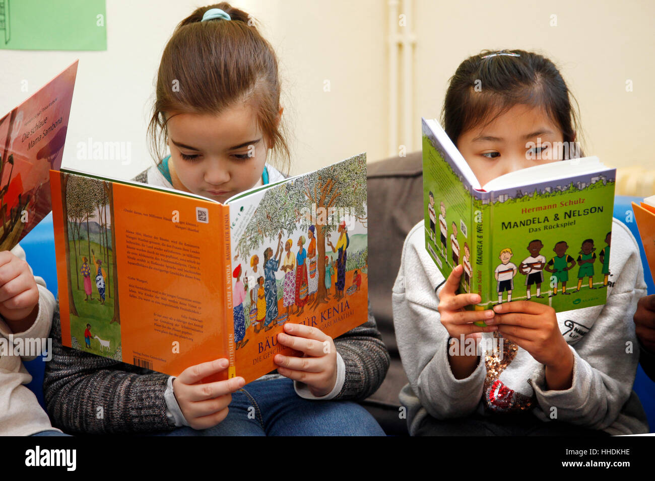 Schülerinnen und Schüler an einer Grundschule lesen Sie Bücher über das Leben in Afrika. Stockfoto