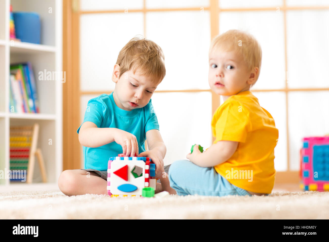 Kinder spielen mit logischen Spielzeug auf weichen Teppich im Kinderzimmer  Roomor Kindergarten. Kinder ordnen und sortieren, Formen und Größen  Stockfotografie - Alamy