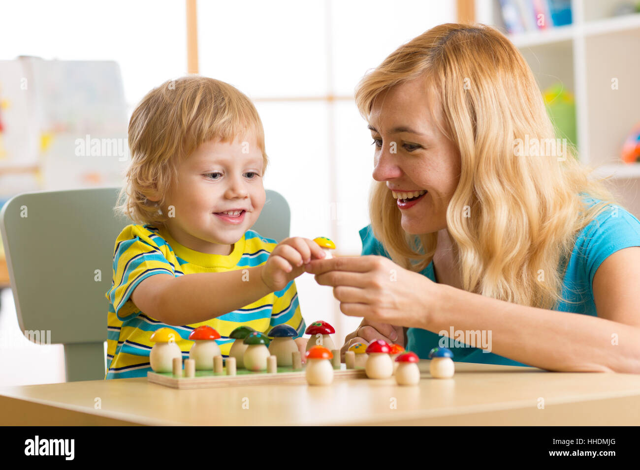 Mutter und Kind Sohn sprechen und Lächeln beim Spielen mit Spielzeug zu Hause Stockfoto