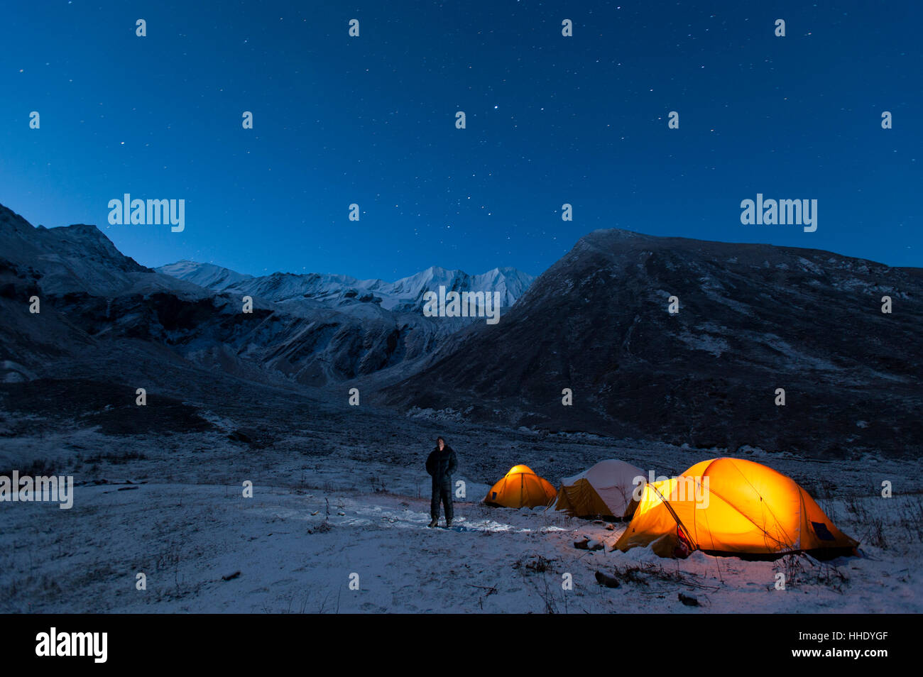 Ein Mann steht vor seinem Zelt in einer kalten Nacht in dem kleinen erkundet Juphal-Tal in der abgelegenen Region Dolpa, Nepal Stockfoto
