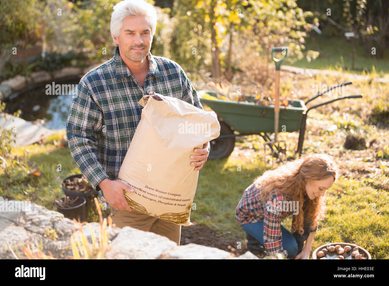 Porträt paar Gartenarbeit Holding Blumenerde im Herbst Garten Stockfoto