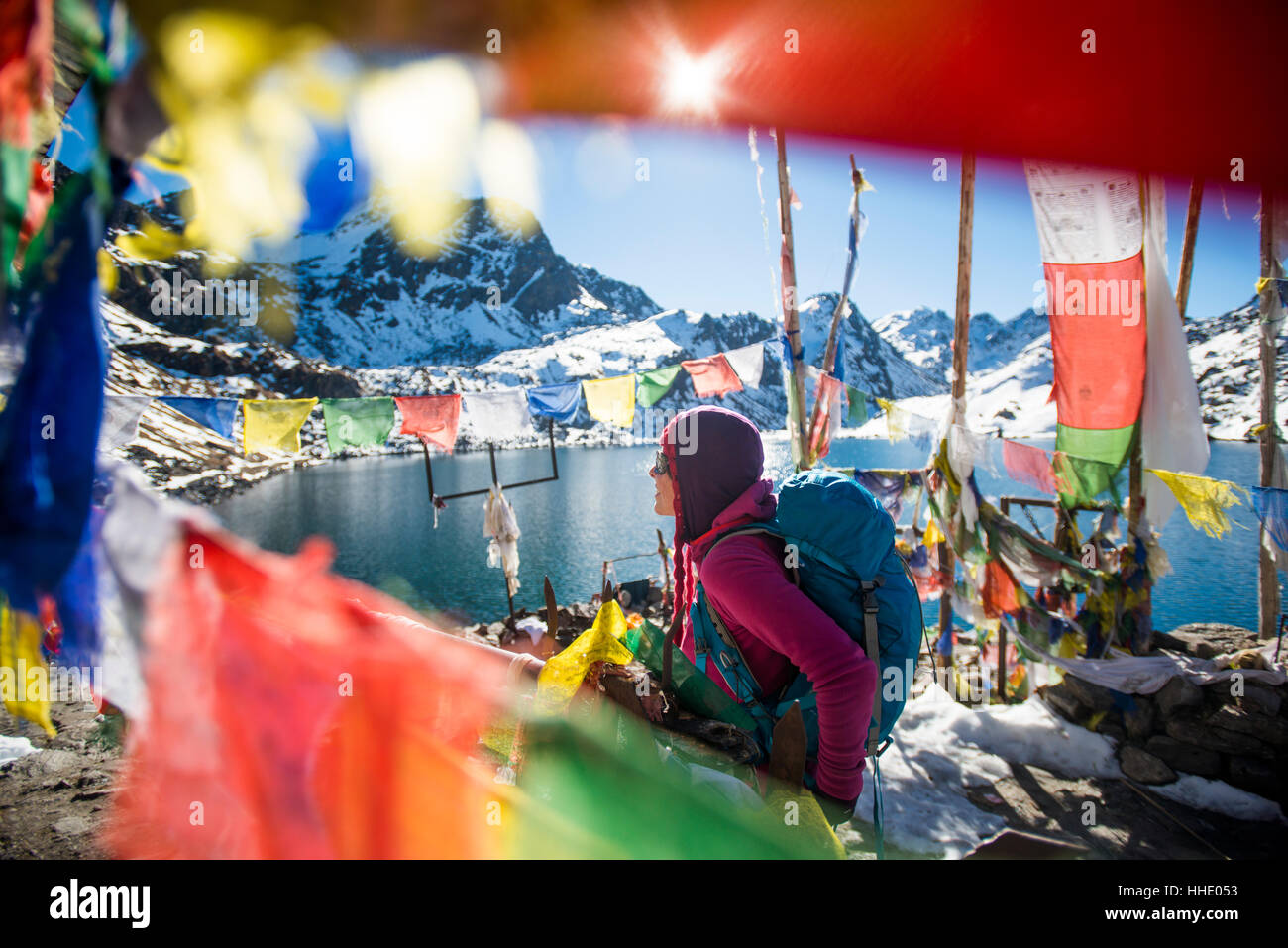 Ein Trekker sticht Gebetsfahnen neben den heiligen Seen bei Gosainkund in der Langtang-Region, Nepal Stockfoto