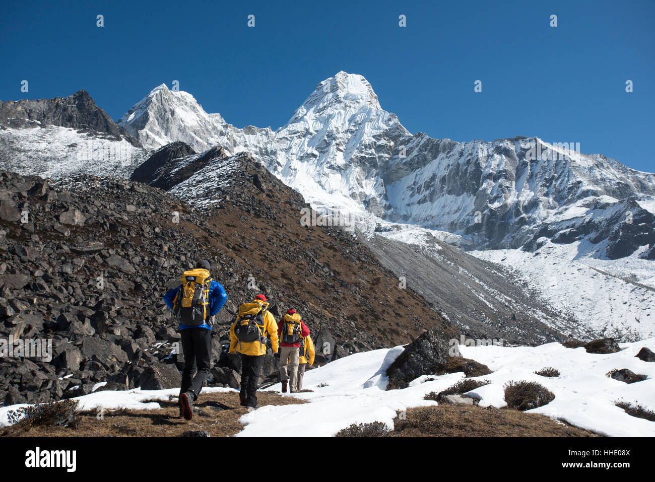 Ein Team von vier Bergsteiger finden ihren Weg zu Ama Dablam Basislager, 6856m Gipfel in der Ferne sehen, Khumbu-Region, Nepal Stockfoto