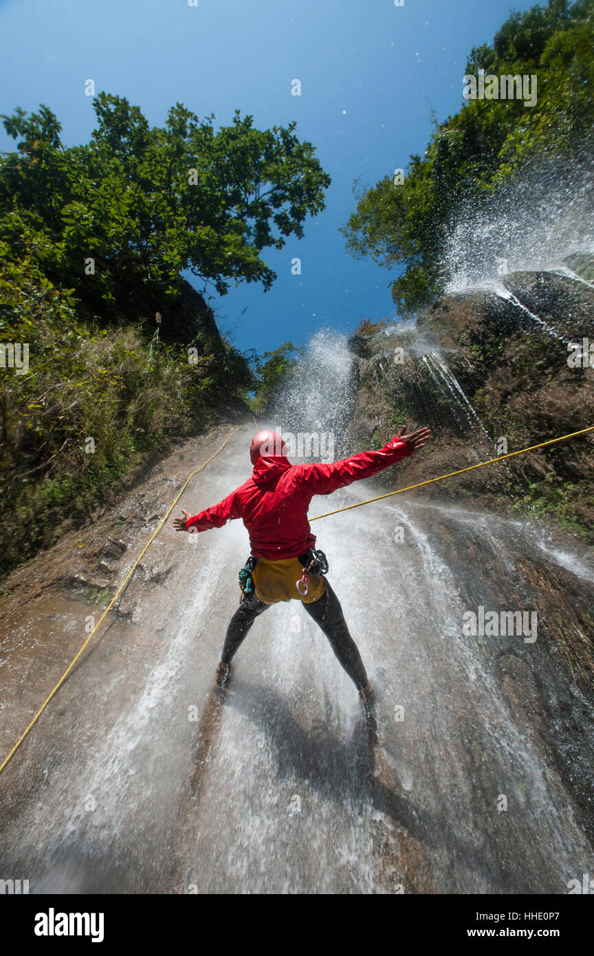 Ein Mann hält seine Arme in das fallende Wasser beim Canyoning, Nepal zu halten Stockfoto