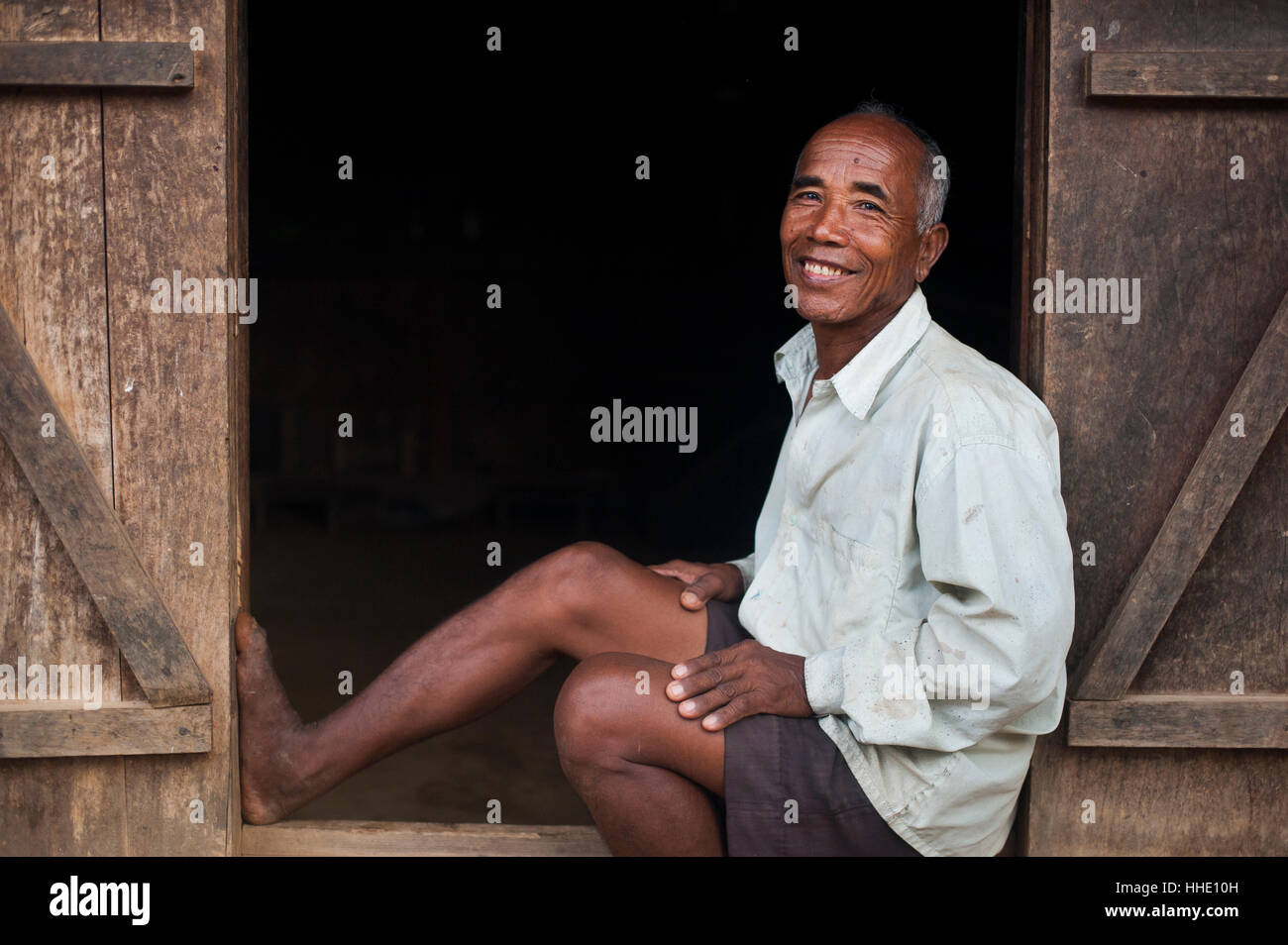 Ein alter Bauer sitzt in der Tür seines Hauses, Meghalaya, Indien Stockfoto