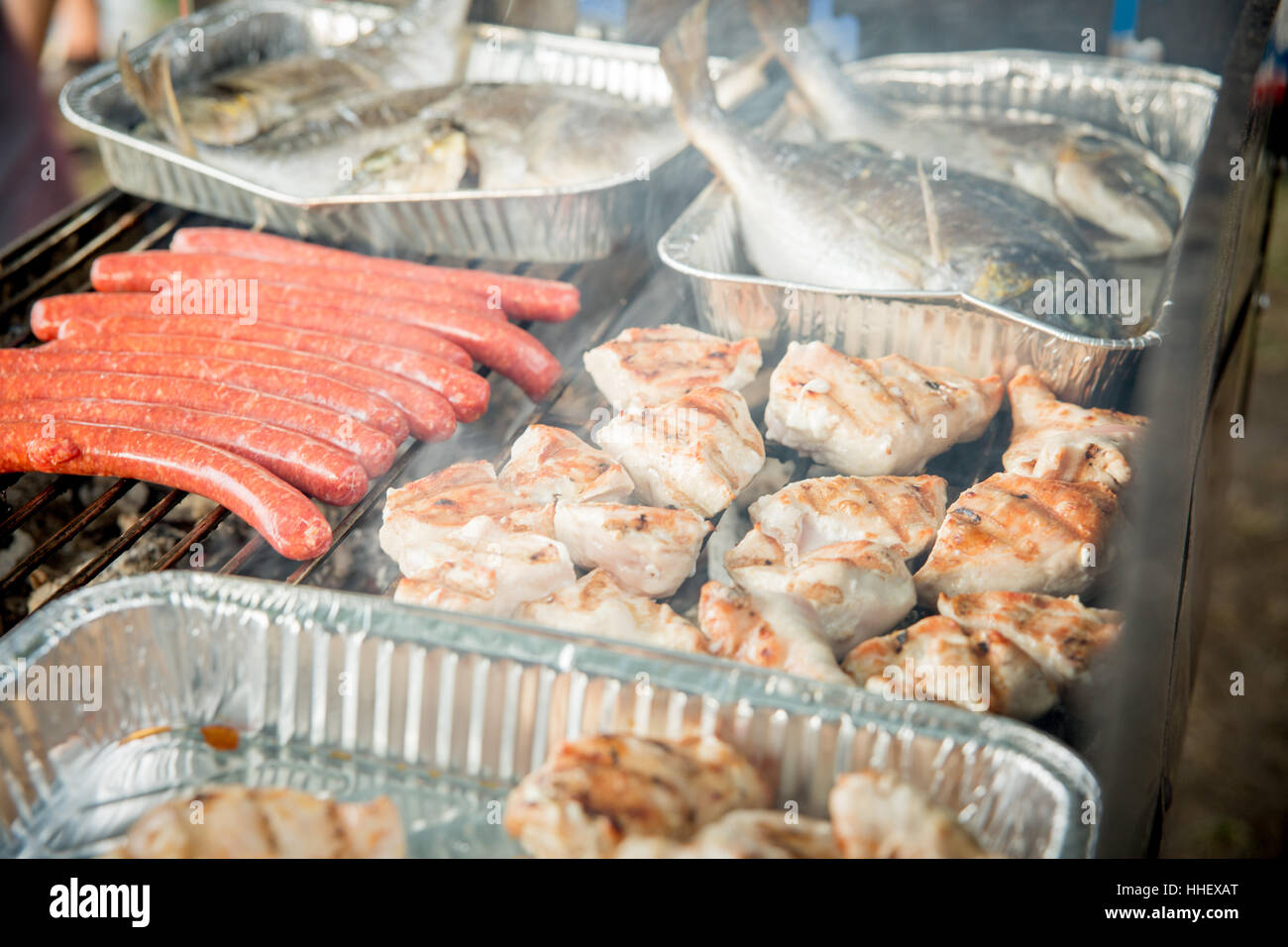 Verschiedene Arten Von Fleisch Auf Einem q Verschiedene Fleischsorten Auf Einem Grill Zum Teil In Aluschalen Stockfotografie Alamy