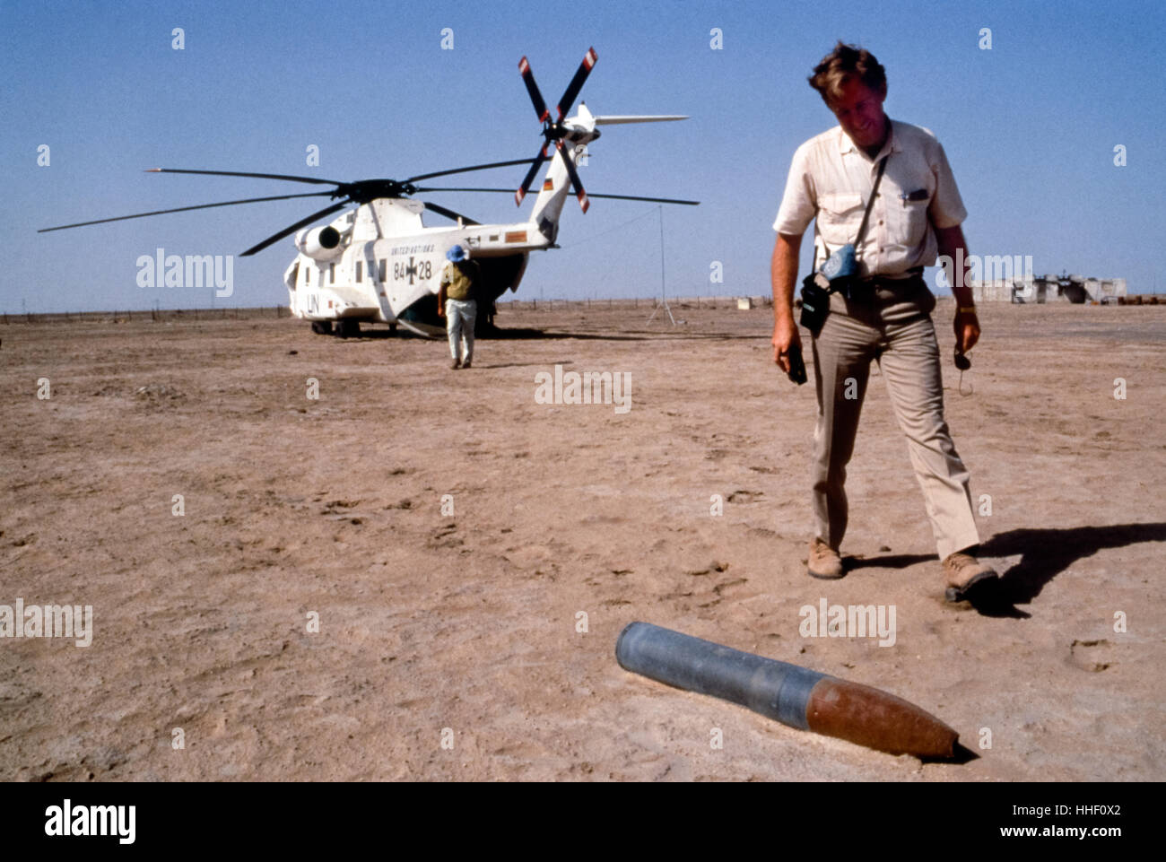 Ein Inspektor, vorbei an einem 122mm explosiven Sprengkopf in der Wüste. Zerstörung von undichten 122mm GB (Sarin) gefüllt Raketen unter Aufsicht der UNSCOM, Khamesiyah, Irak Stockfoto