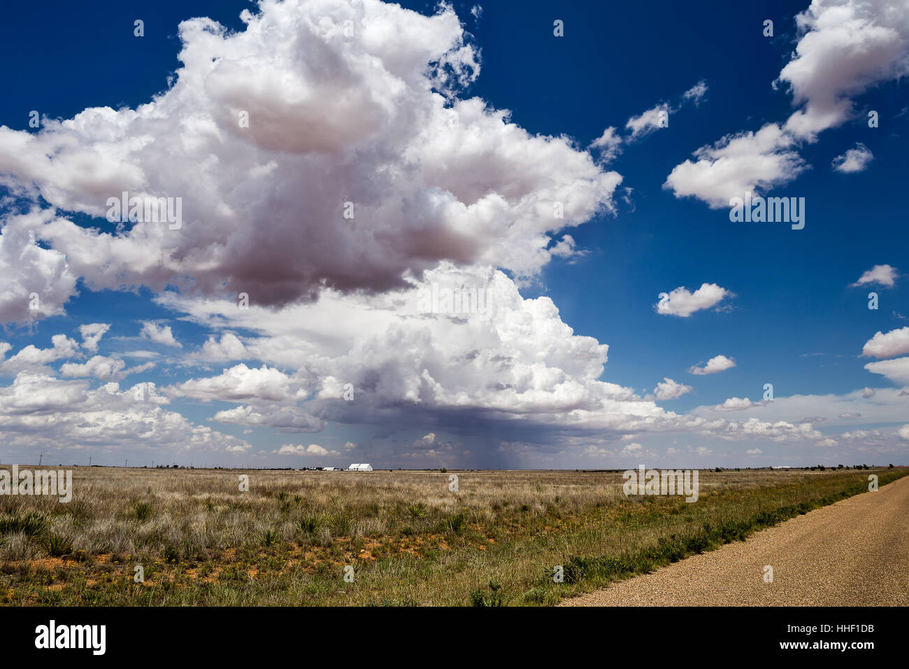 Blauer Himmel mit weißen Cumulus-Wolken über und öffnen Feld-Hof Stockfoto
